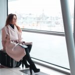 Passenger woman in airport waiting for air travel.