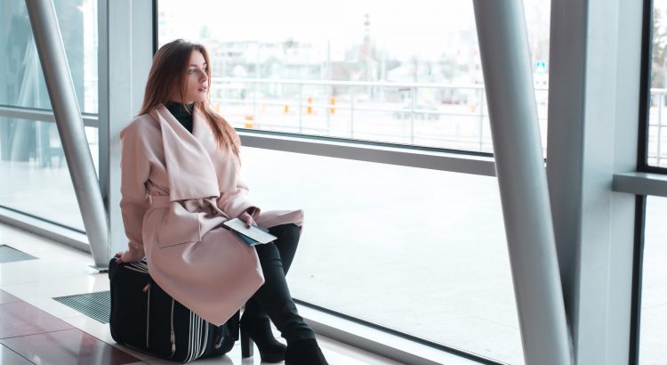 Passenger woman in airport waiting for air travel.