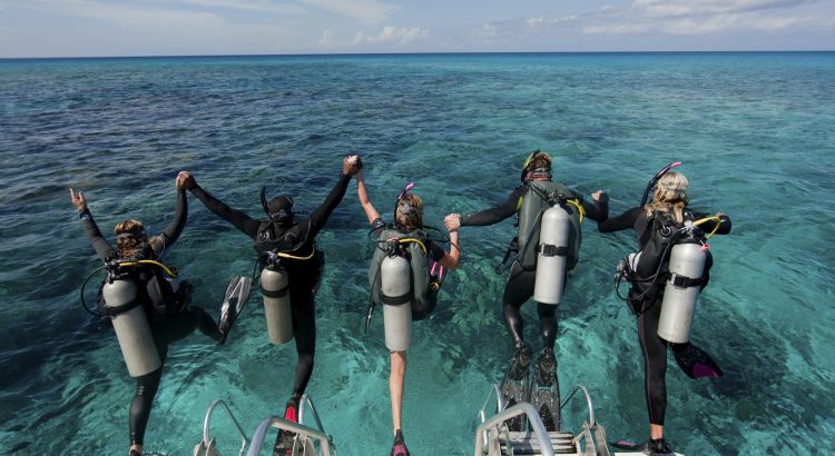 Scuba divers enter water from boat via giant stride entry.,Diving into the water.