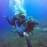 Underwater scuba diving selfie shot with selfie stick. Deep blue sea. Wide angle shot.